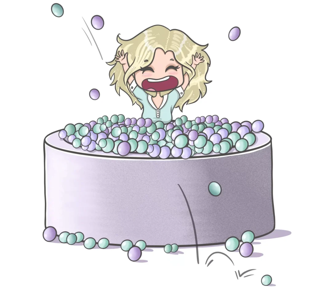 Szczęśliwa Karolina buszuje w basenie z kulkami. Bawi się świetnie, jest w swoim żywiole.